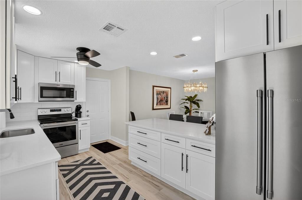 Chandelier, Dining room, Interior, Kitchen, Recessed Lighting, Stainless Steel Appliances, Wood Texture Flooring