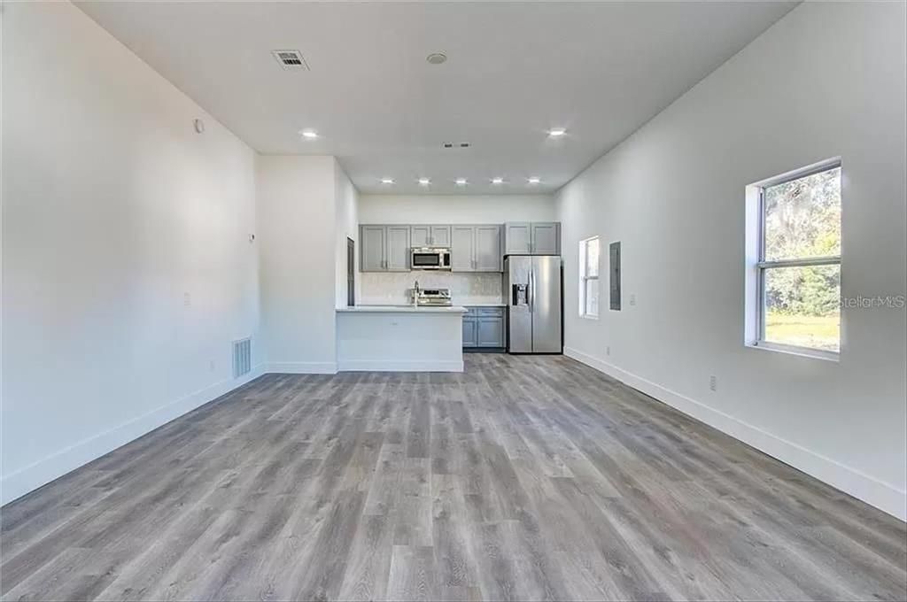 Empty room, Interior, Kitchen, Recessed Lighting, Stainless Steel Appliances, Wood Texture Flooring