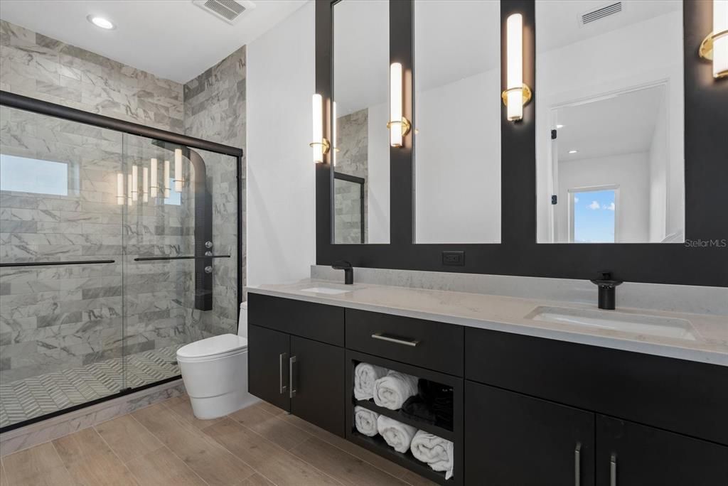 Bathroom, Dual Sink Vanities, Glass Shower, Interior, Marble Walls, Recessed Lighting, Wood Texture Flooring