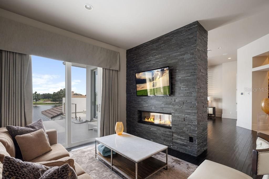 Fireplace, Interior, Living room, Recessed Lighting, Stone Walls, Water, Wood Texture Flooring