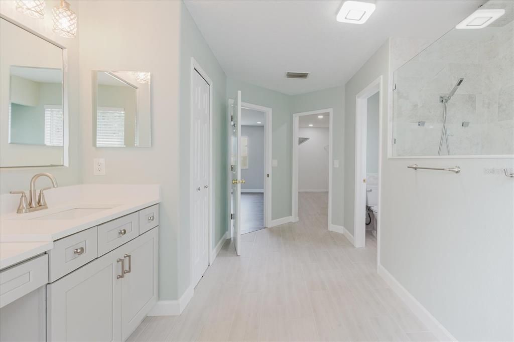 Bathroom, Dual Sink Vanities, Interior, Marble Walls, Recessed Lighting, Wood Texture Flooring