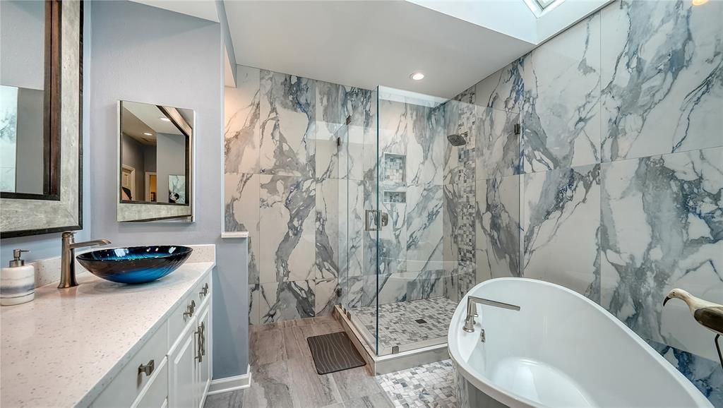 Bathroom, Dual Sink Vanities, Free Standing Baths, Glass Shower, Interior, Marble Walls, Recessed Lighting, Wood Texture Flooring