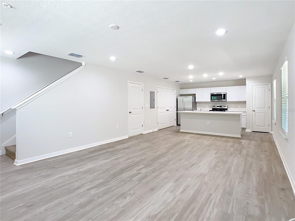 Empty room, Interior, Kitchen, Recessed Lighting, Stainless Steel Appliances, Wood Texture Flooring