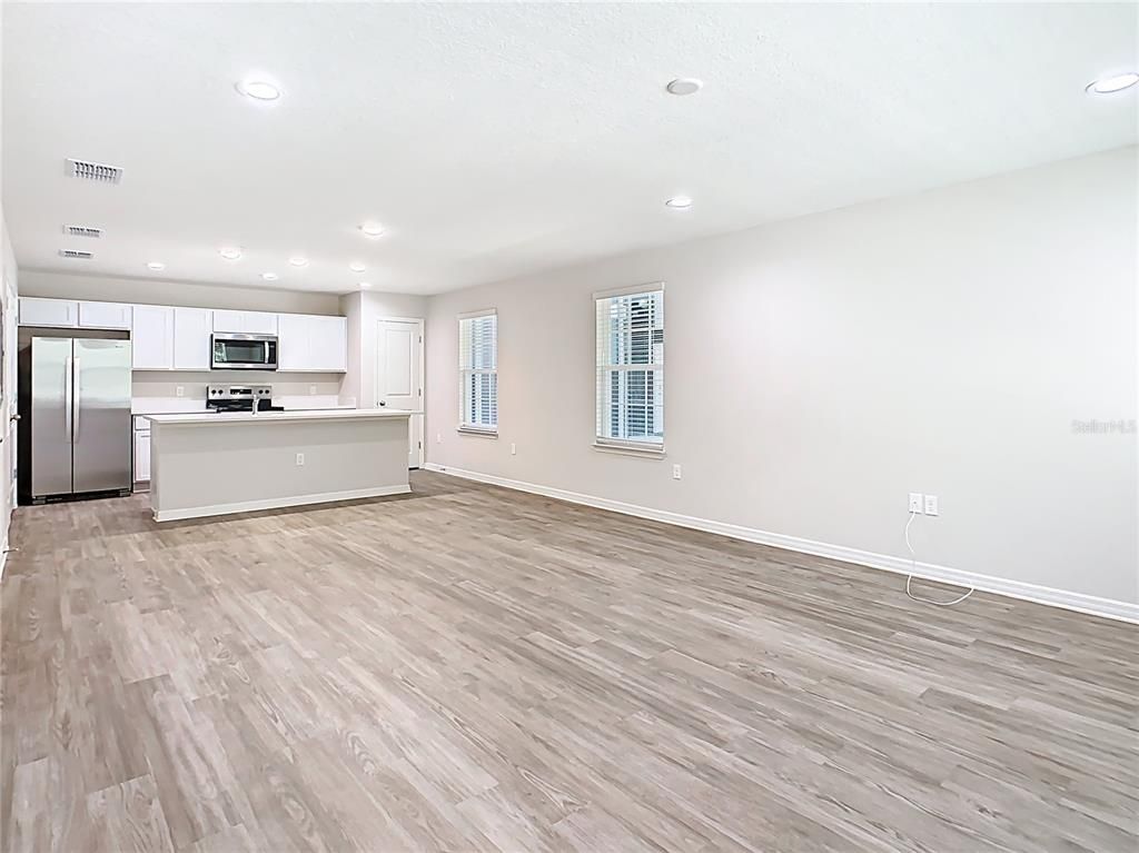 Empty room, Interior, Kitchen, Recessed Lighting, Stainless Steel Appliances, Wood Texture Flooring