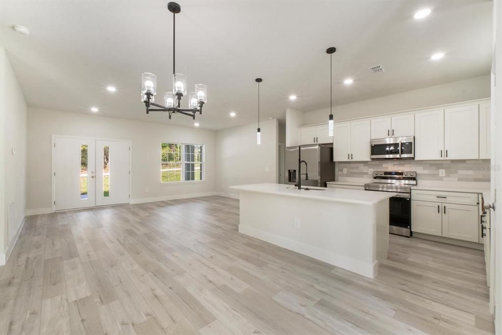 Chandelier, Empty room, Interior, Kitchen, Pendant Lights, Recessed Lighting, Stainless Steel Appliances, Wood Texture Flooring