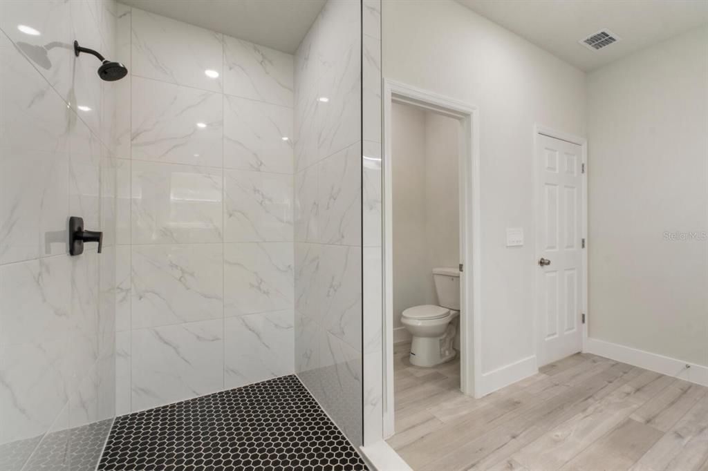 Bathroom, Glass Shower, Interior, Marble Walls, Recessed Lighting, Wood Texture Flooring