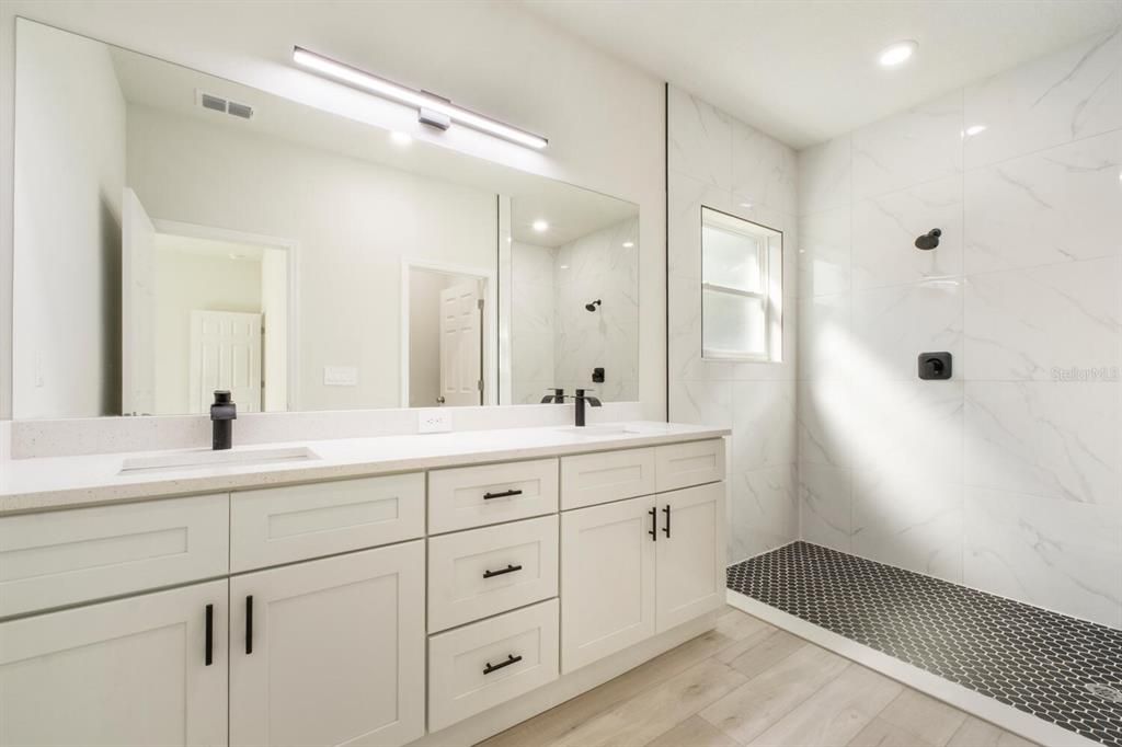 Bathroom, Dual Sink Vanities, Glass Shower, Interior, Marble Walls, Recessed Lighting, Wood Texture Flooring