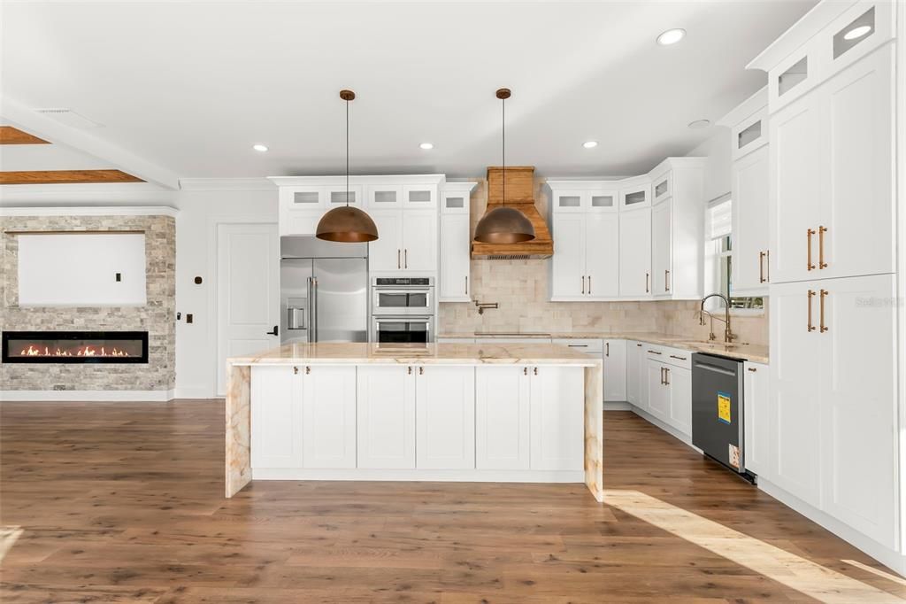 Fireplace, Interior, Kitchen, Pendant Lights, Recessed Lighting, Stainless Steel Appliances, Stone Walls, Wood Texture Flooring