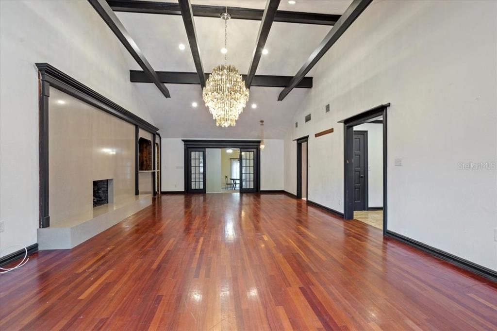 Chandelier, Empty room, Fireplace, Interior, Recessed Lighting, Wooden Beams, Wood Texture Flooring