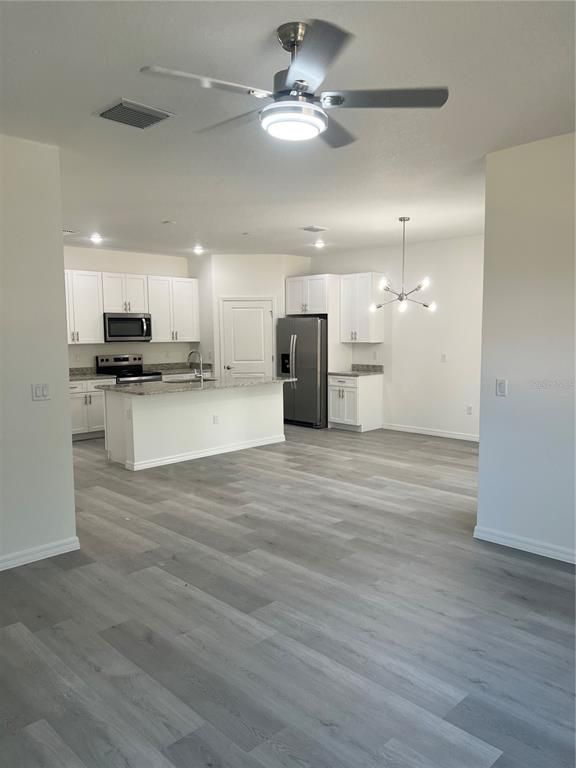 Empty room, Interior, Kitchen, Pendant Lights, Recessed Lighting, Stainless Steel Appliances, Wood Texture Flooring