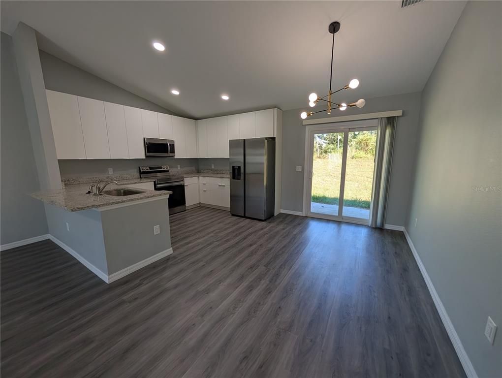 Empty room, Interior, Kitchen, Pendant Lights, Recessed Lighting, Stainless Steel Appliances, Wood Texture Flooring