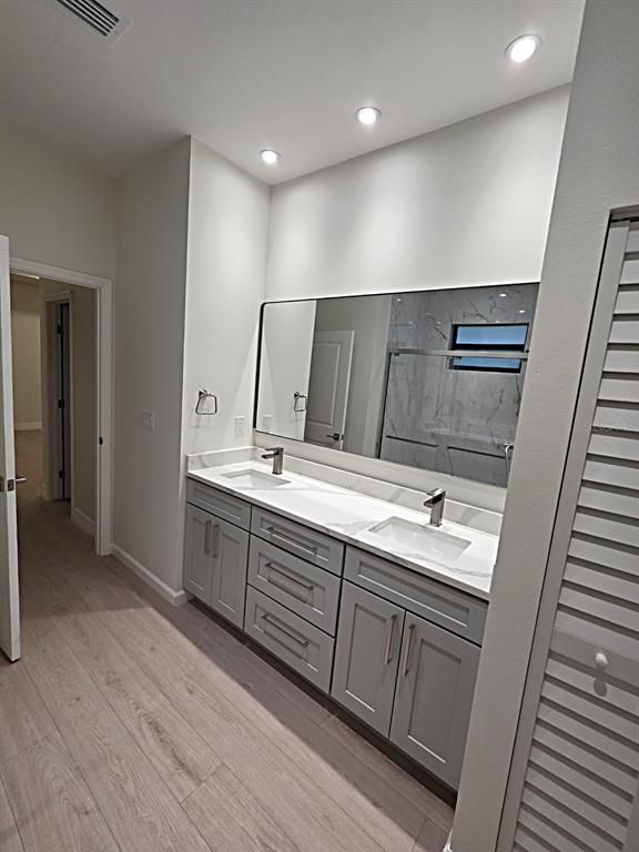 Bathroom, Dual Sink Vanities, Interior, Marble Walls, Recessed Lighting, Wood Texture Flooring