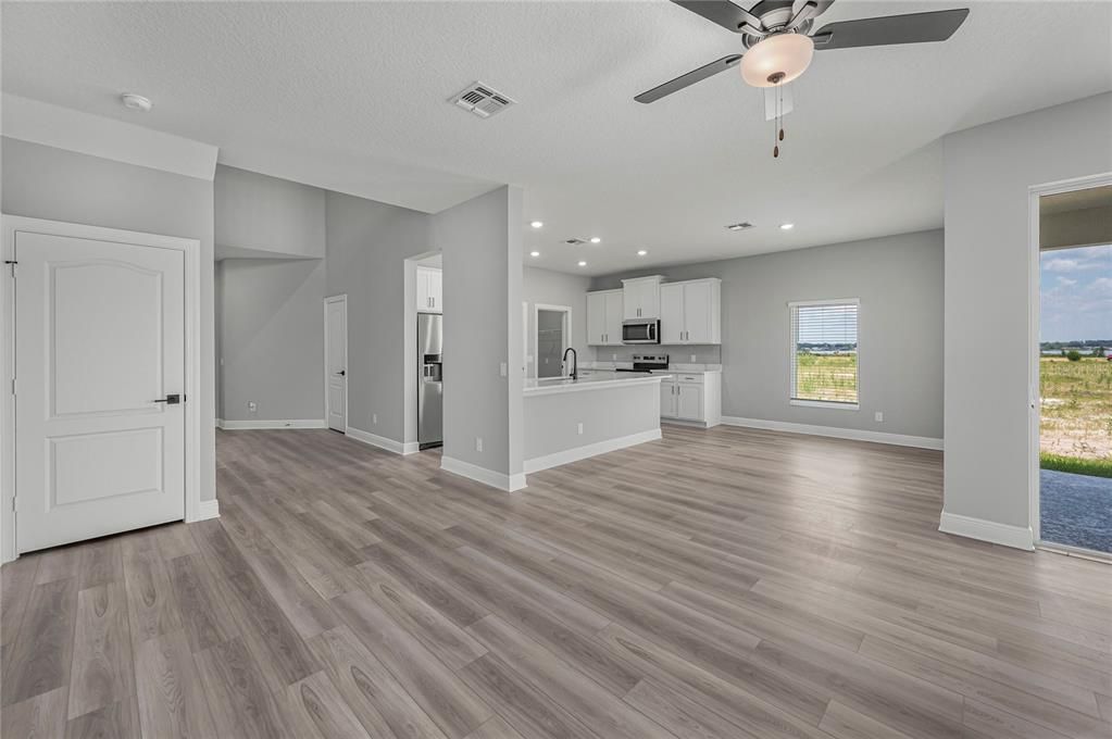 Empty room, Interior, Kitchen, Recessed Lighting, Stainless Steel Appliances, Wood Texture Flooring