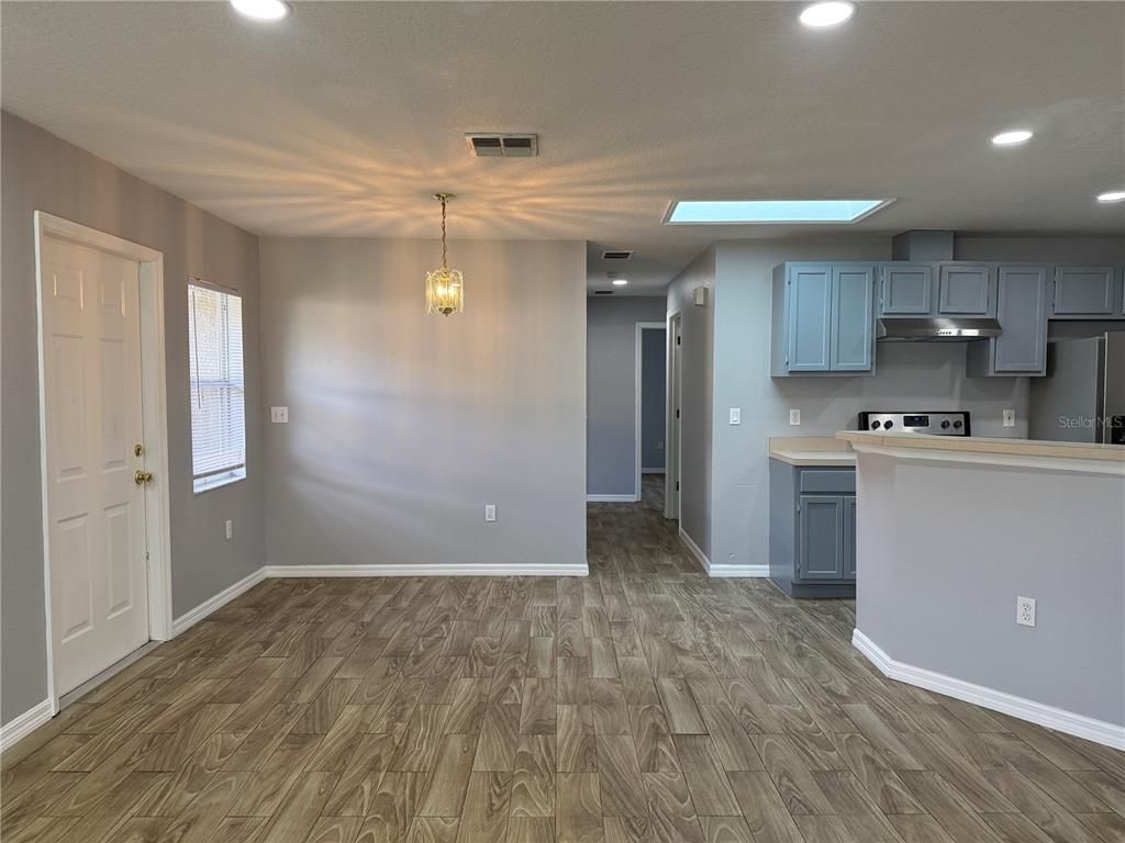 Empty room, Interior, Kitchen, Pendant Lights, Recessed Lighting, Stainless Steel Appliances, Wood Texture Flooring