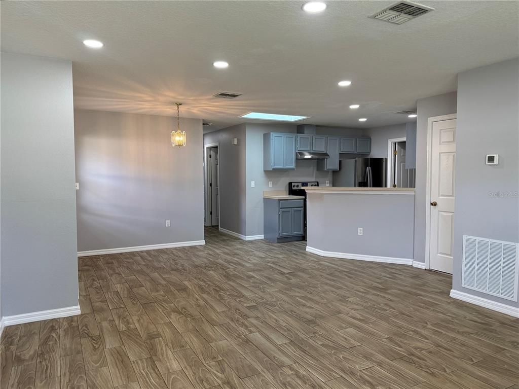 Empty room, Interior, Kitchen, Pendant Lights, Recessed Lighting, Stainless Steel Appliances, Wood Texture Flooring