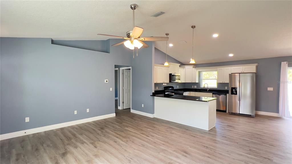 Empty room, Interior, Kitchen, Pendant Lights, Recessed Lighting, Stainless Steel Appliances, Wood Texture Flooring