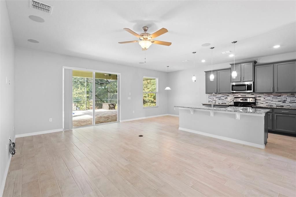Empty room, Interior, Kitchen, Pendant Lights, Recessed Lighting, Stainless Steel Appliances, Wood Texture Flooring