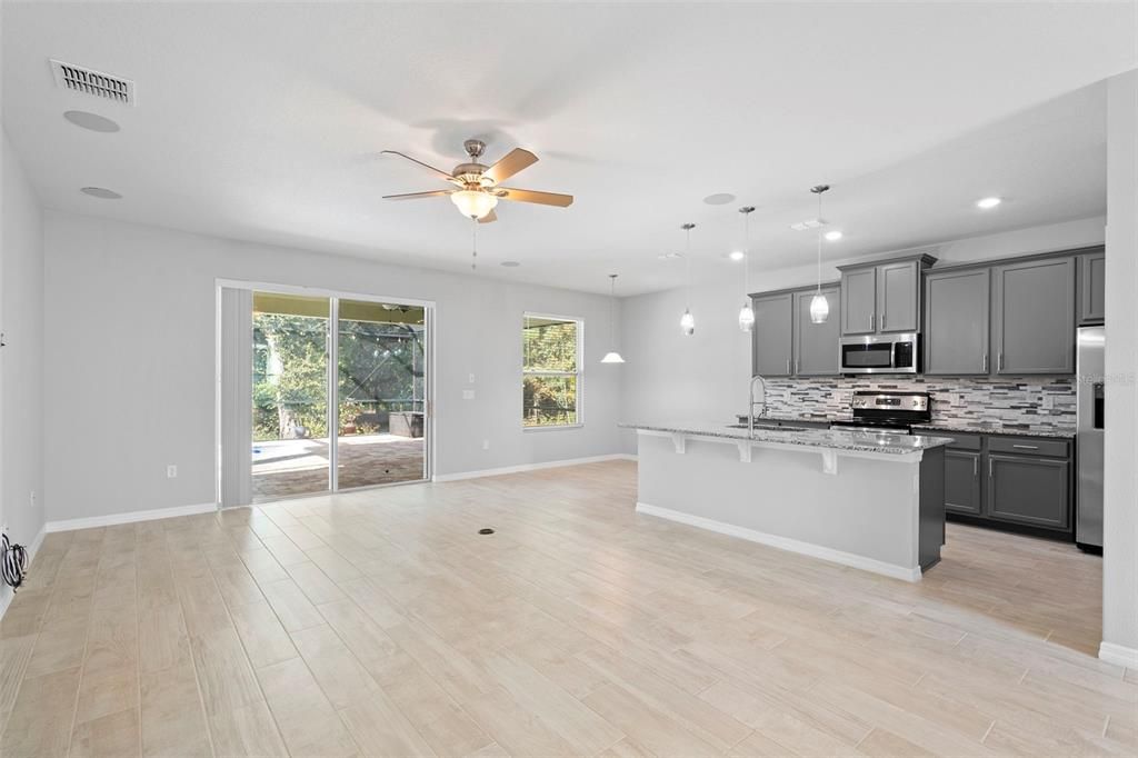Empty room, Interior, Kitchen, Pendant Lights, Recessed Lighting, Stainless Steel Appliances, Wood Texture Flooring