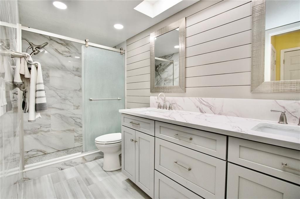 Bathroom, Dual Sink Vanities, Glass Shower, Interior, Marble Walls, Recessed Lighting, Wood Texture Flooring