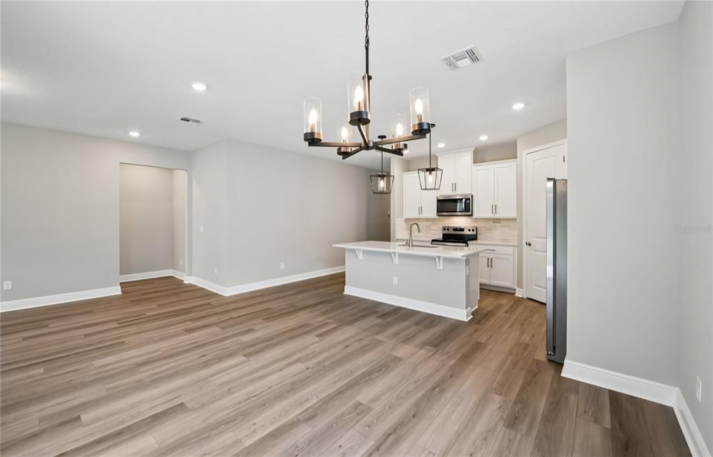 Chandelier, Empty room, Interior, Kitchen, Pendant Lights, Recessed Lighting, Stainless Steel Appliances, Wood Texture Flooring