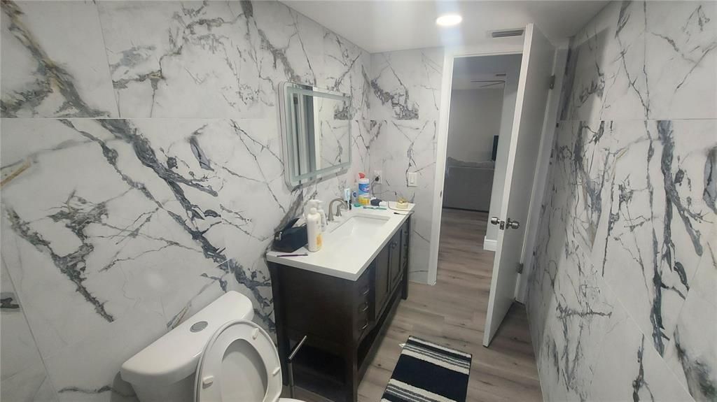 Bathroom, Dual Sink Vanities, Interior, Marble Walls, Recessed Lighting, Wood Texture Flooring