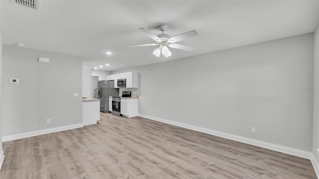 Empty room, Interior, Kitchen, Recessed Lighting, Stainless Steel Appliances, Wood Texture Flooring