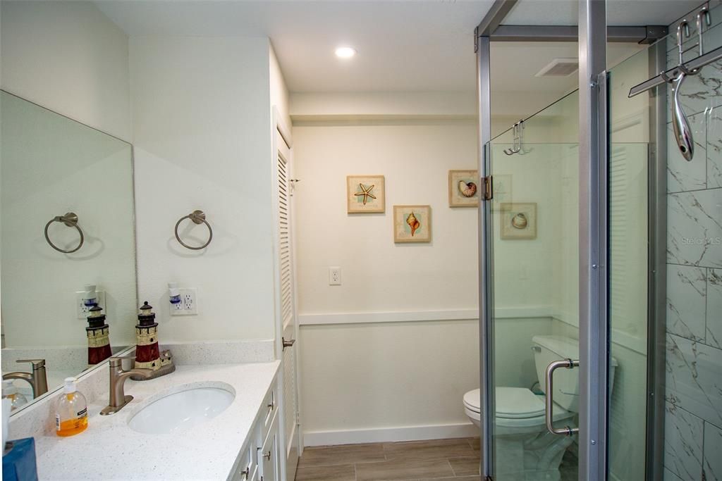 Bathroom, Glass Shower, Interior, Marble Walls, Recessed Lighting, Wood Texture Flooring