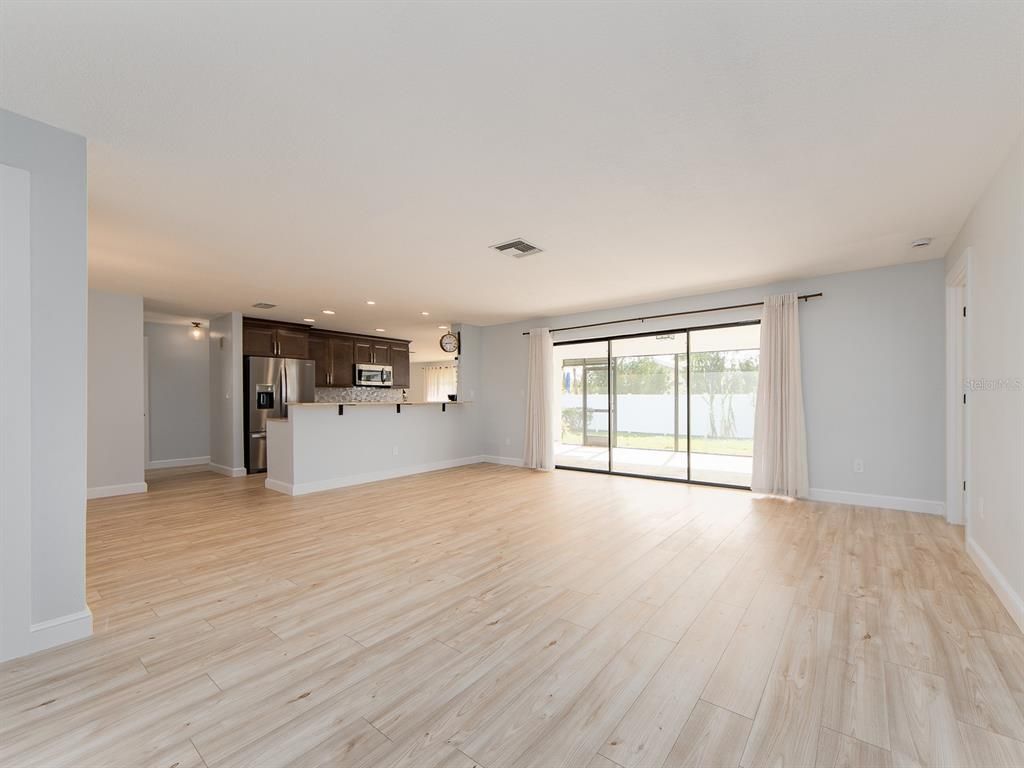 Empty room, Interior, Kitchen, Recessed Lighting, Stainless Steel Appliances, Wood Texture Flooring