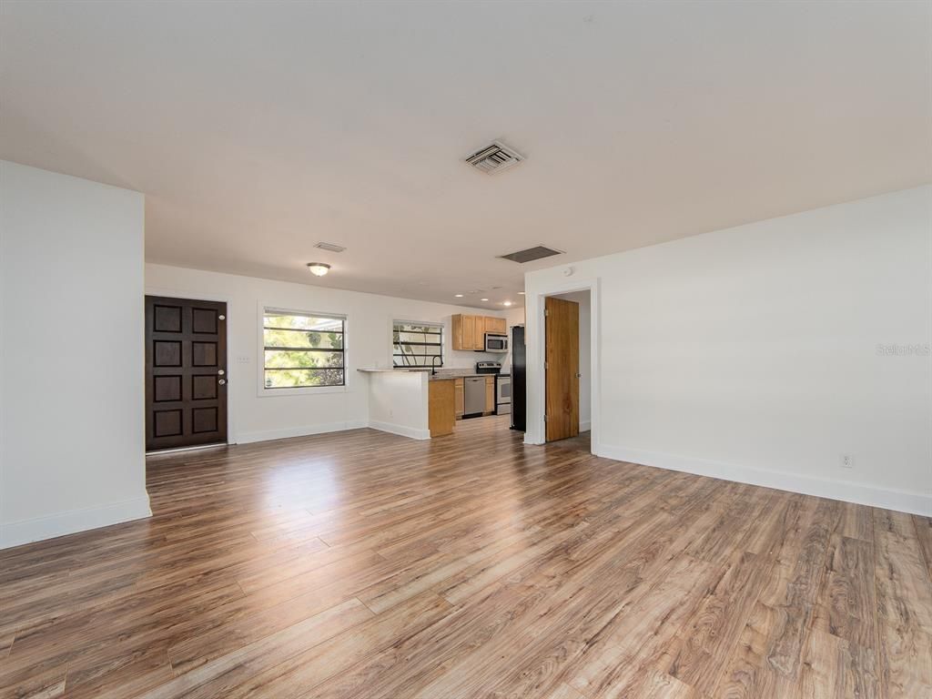 Empty room, Interior, Kitchen, Recessed Lighting, Stainless Steel Appliances, Wood Texture Flooring