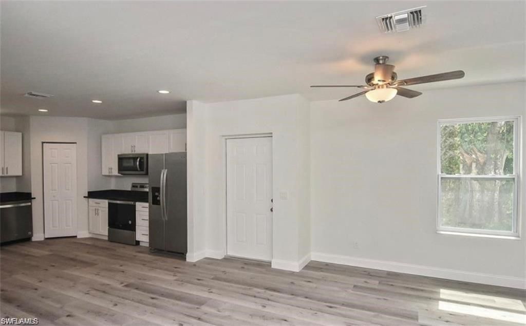 Empty room, Interior, Kitchen, Recessed Lighting, Stainless Steel Appliances, Wood Texture Flooring