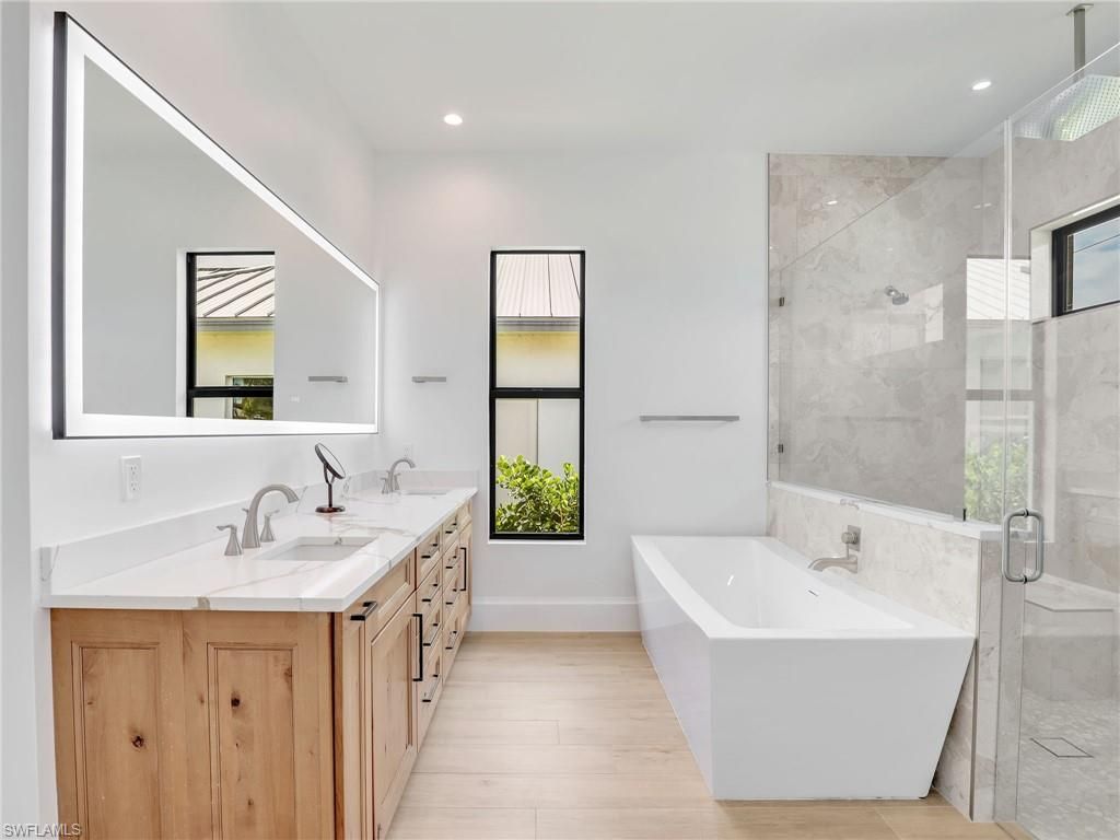 Bathroom, Dual Sink Vanities, Free Standing Baths, Glass Shower, Interior, Marble Walls, Recessed Lighting, Wood Texture Flooring