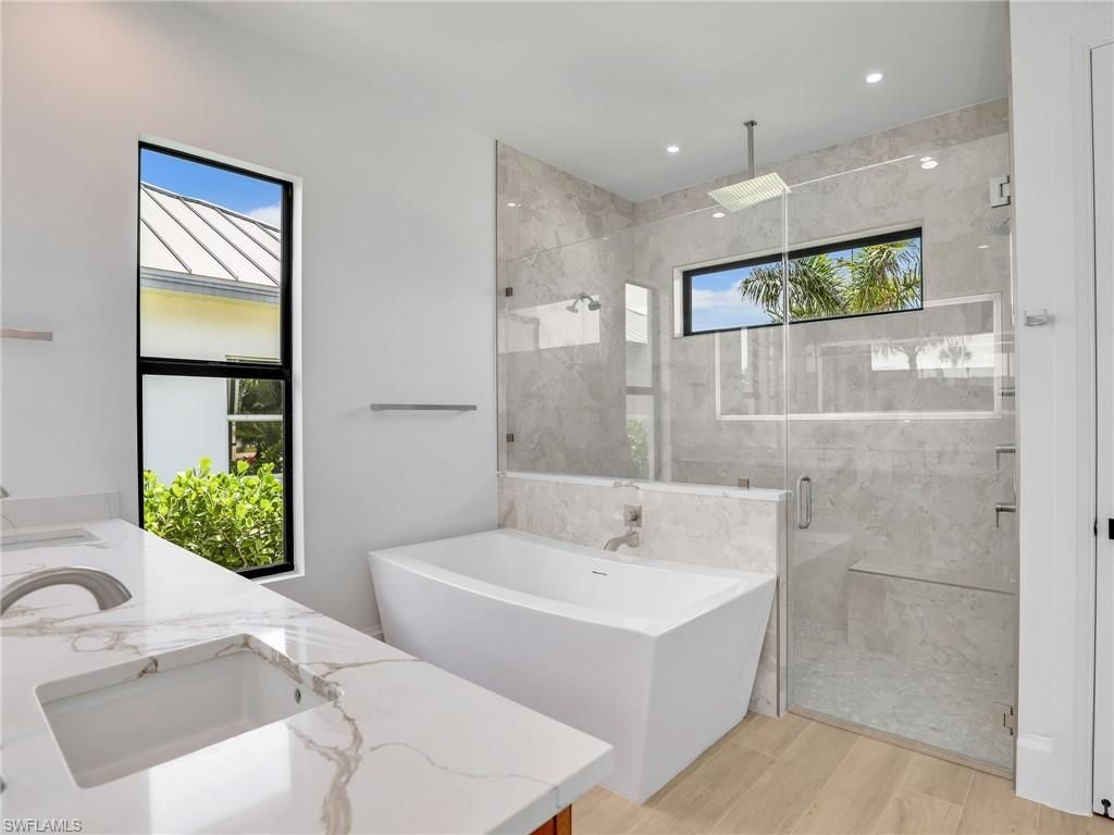 Bathroom, Dual Sink Vanities, Free Standing Baths, Glass Shower, Interior, Marble Walls, Recessed Lighting, Wood Texture Flooring