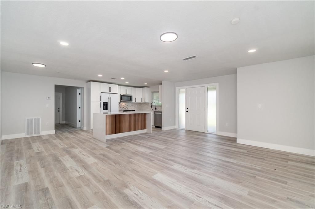 Empty room, Interior, Kitchen, Recessed Lighting, Stainless Steel Appliances, Wood Texture Flooring