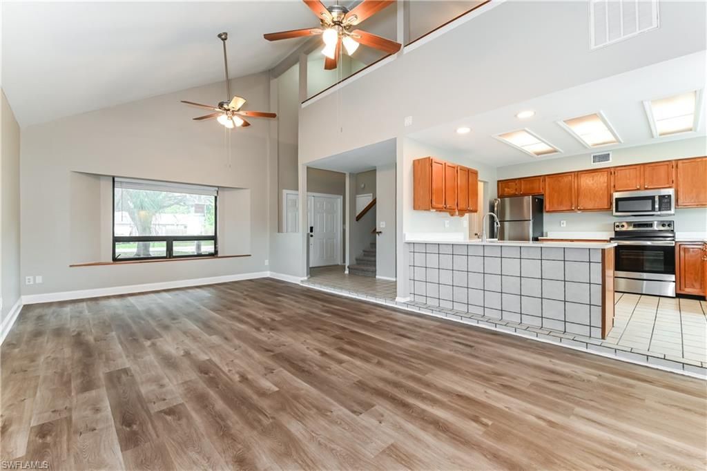 Empty room, Interior, Kitchen, Recessed Lighting, Stainless Steel Appliances, Wood Texture Flooring