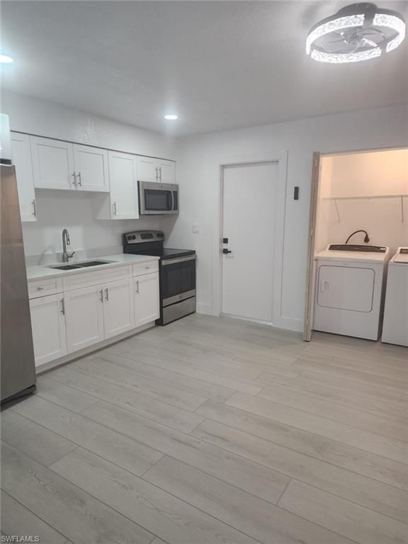 Interior, Kitchen, Recessed Lighting, Washer, Wood Texture Flooring
