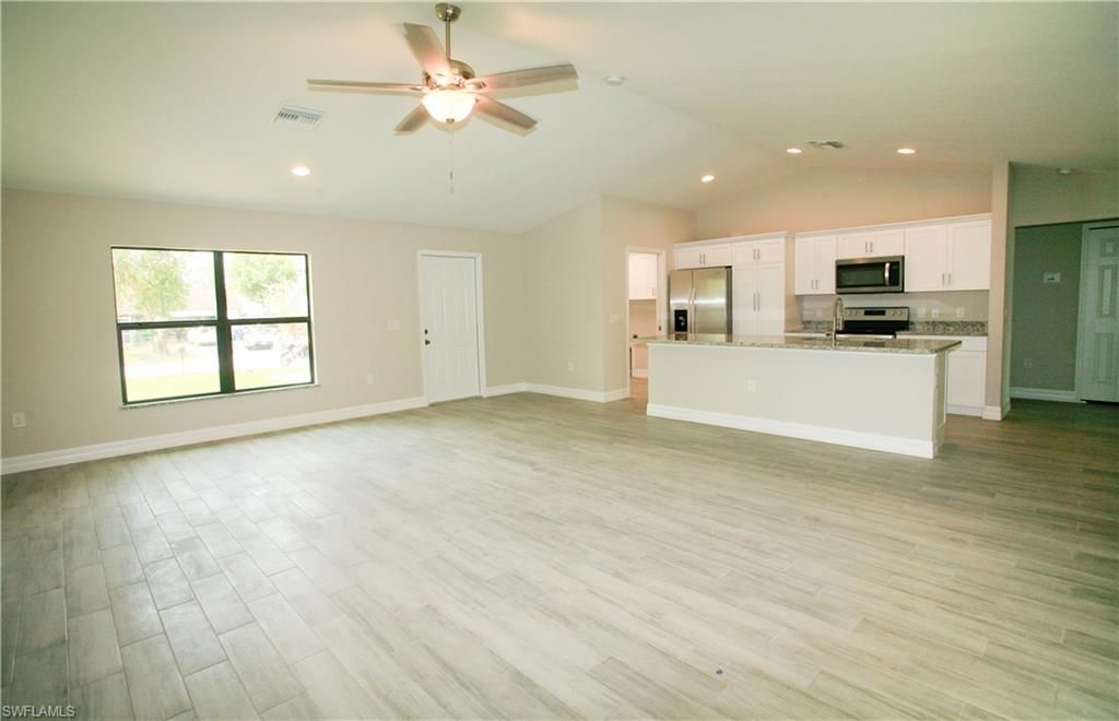 Empty room, Interior, Kitchen, Recessed Lighting, Stainless Steel Appliances, Wood Texture Flooring