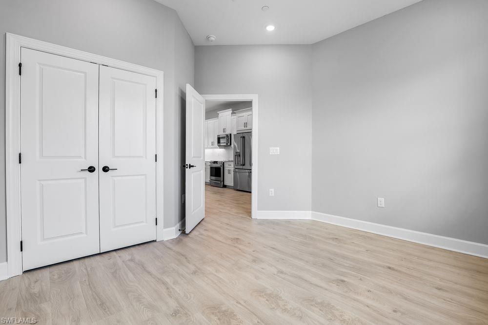 Empty room, Interior, Kitchen, Recessed Lighting, Stainless Steel Appliances, Wood Texture Flooring