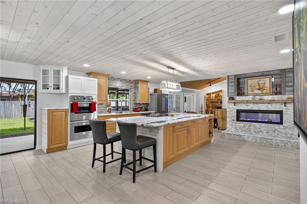 Fireplace, Interior, Kitchen, Pendant Lights, Recessed Lighting, Stainless Steel Appliances, Stone Walls, Wooden Ceilings, Wood Texture Flooring