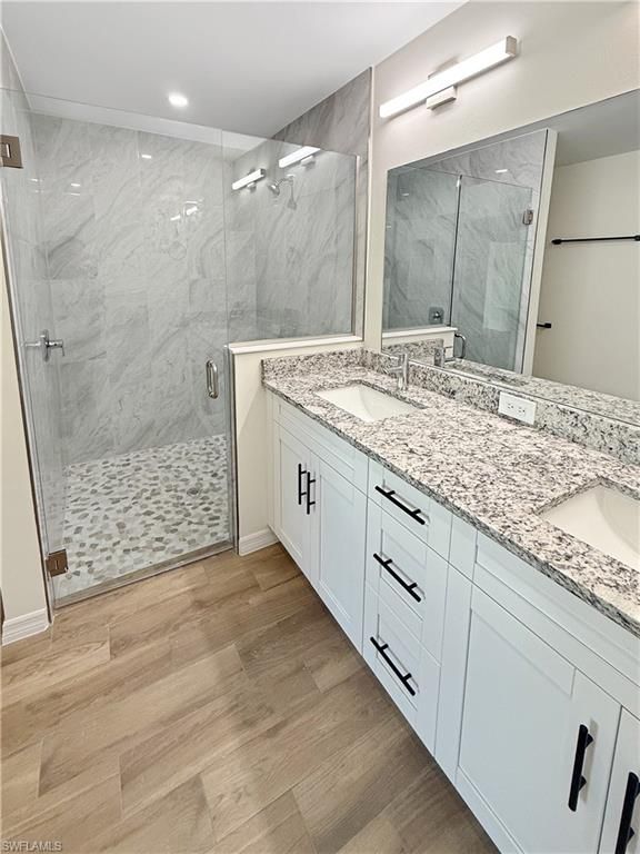 Bathroom, Dual Sink Vanities, Glass Shower, Interior, Marble Walls, Recessed Lighting, Wood Texture Flooring