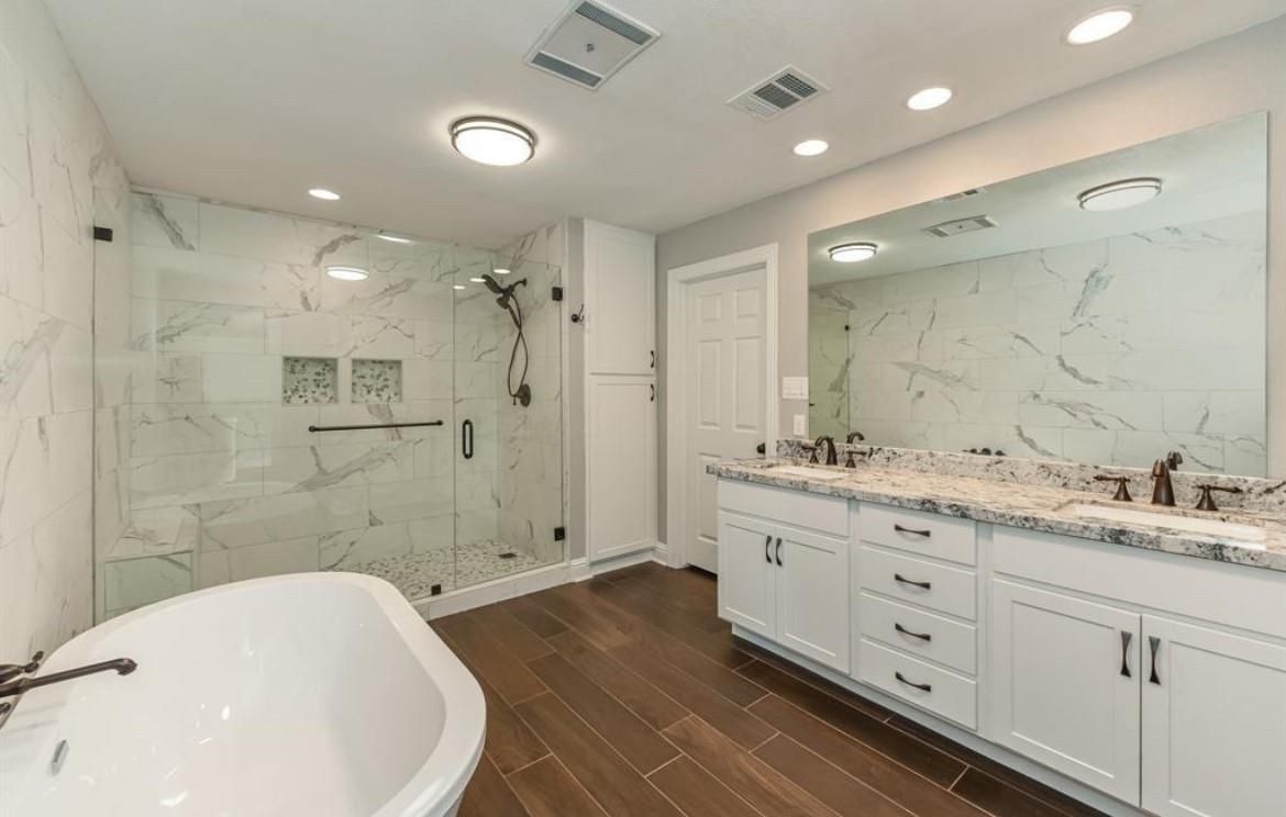 Bathroom, Dual Sink Vanities, Free Standing Baths, Glass Shower, Interior, Marble Walls, Recessed Lighting, Wood Texture Flooring