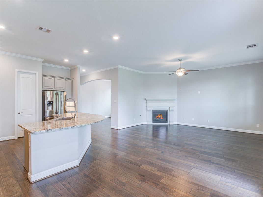 Empty room, Fireplace, Interior, Kitchen, Recessed Lighting, Stainless Steel Appliances, Wood Texture Flooring
