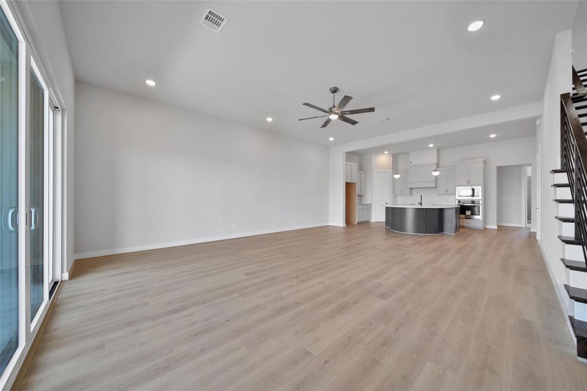 Empty room, Interior, Kitchen, Recessed Lighting, Stainless Steel Appliances, Wood Texture Flooring