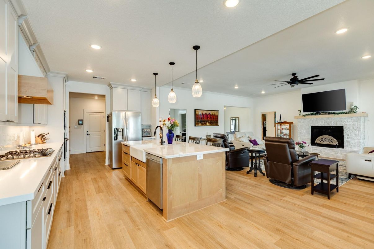 Fireplace, Interior, Kitchen, Living room, Pendant Lights, Recessed Lighting, Stainless Steel Appliances, Stone Walls, Wood Texture Flooring