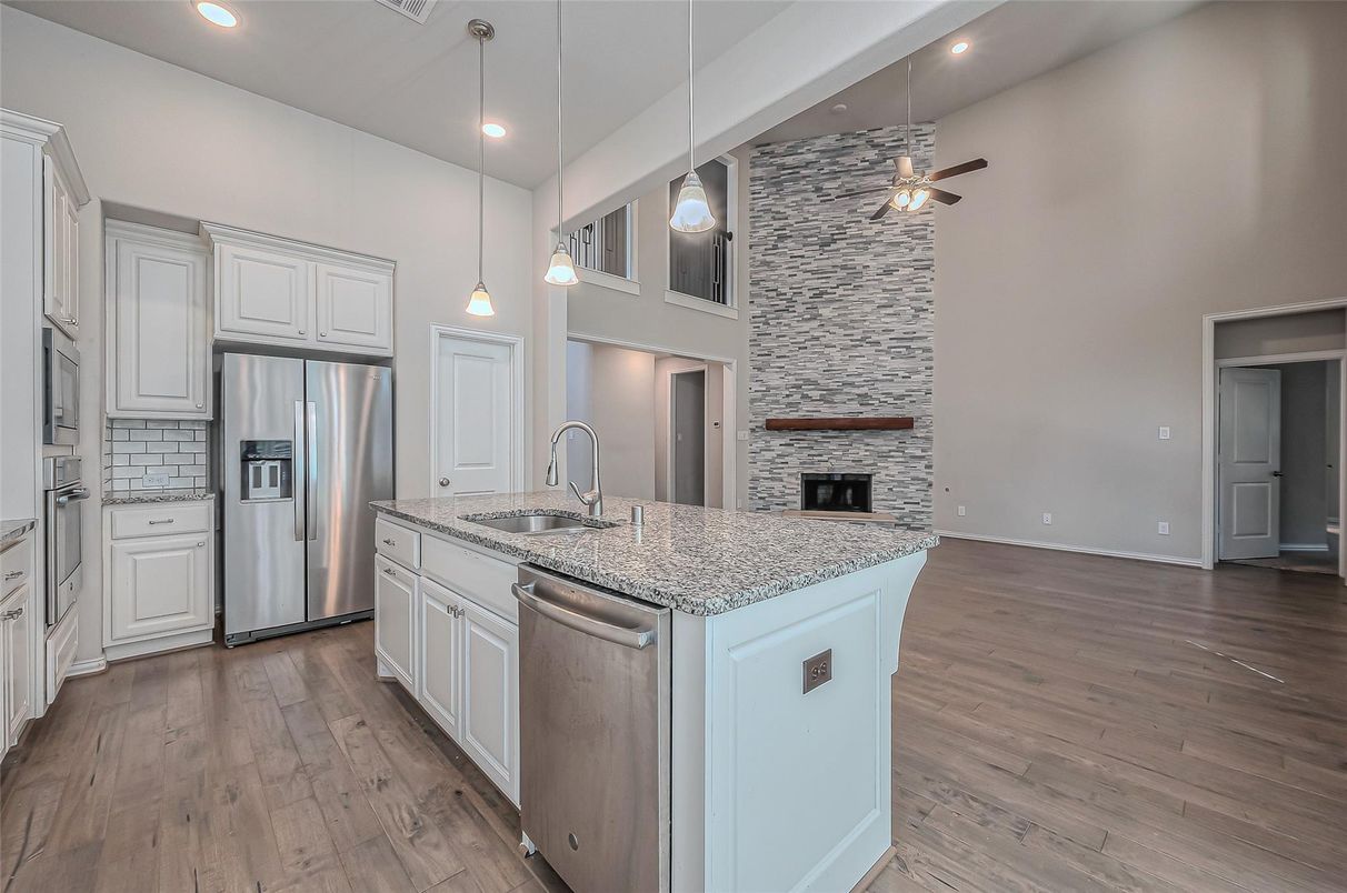 Fireplace, Interior, Kitchen, Pendant Lights, Recessed Lighting, Stainless Steel Appliances, Stone Walls, Wood Texture Flooring