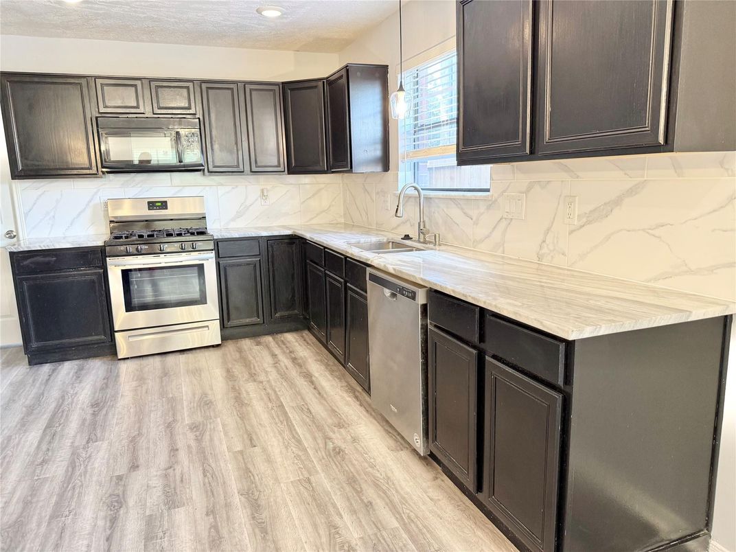 Interior, Kitchen, Marble Walls, Recessed Lighting, Stainless Steel Appliances, Wood Texture Flooring