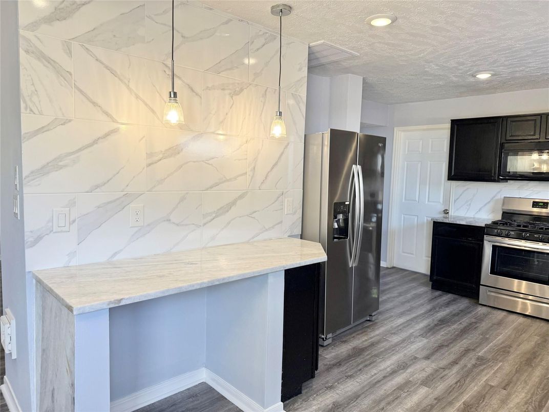 Interior, Kitchen, Marble Walls, Pendant Lights, Recessed Lighting, Stainless Steel Appliances, Wood Texture Flooring
