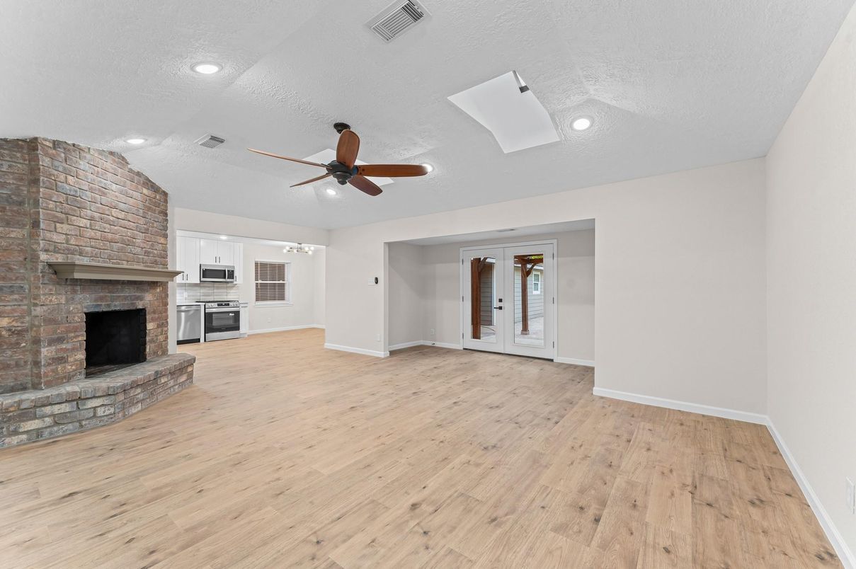 Empty room, Fireplace, Interior, Kitchen, Recessed Lighting, Stone Walls, Wood Texture Flooring