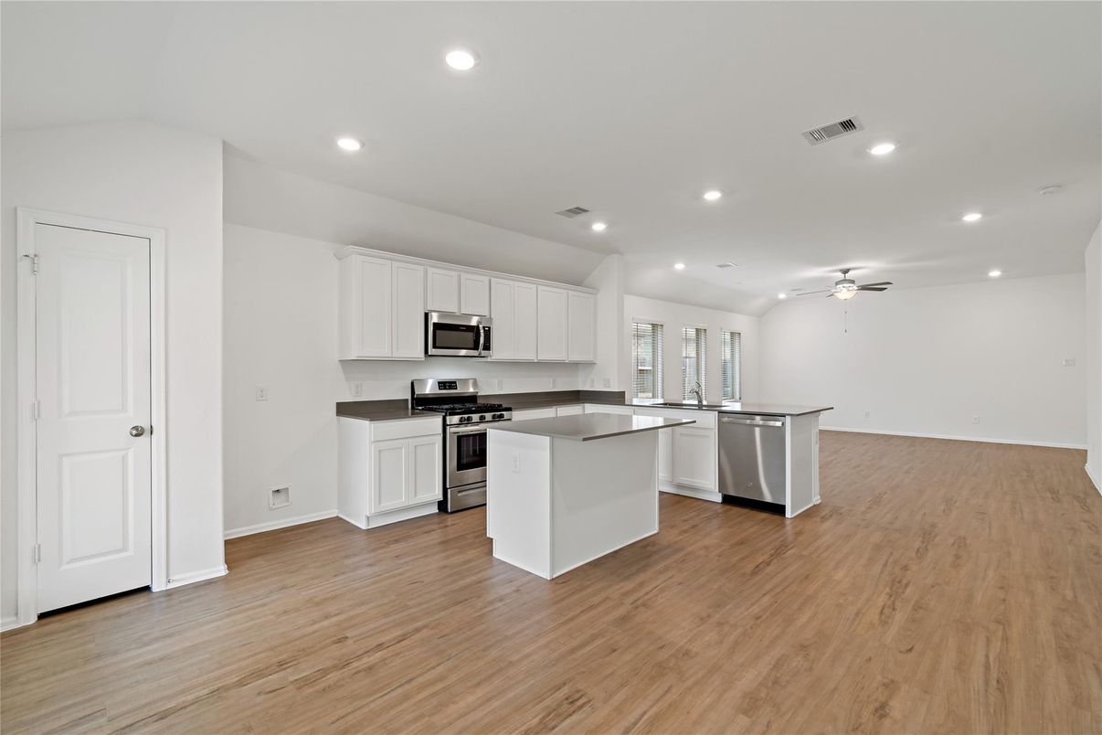 Empty room, Interior, Kitchen, Recessed Lighting, Stainless Steel Appliances, Wood Texture Flooring
