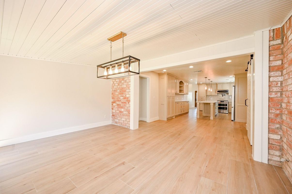 Empty room, Interior, Kitchen, Pendant Lights, Recessed Lighting, Stainless Steel Appliances, Stone Walls, Wood Texture Flooring