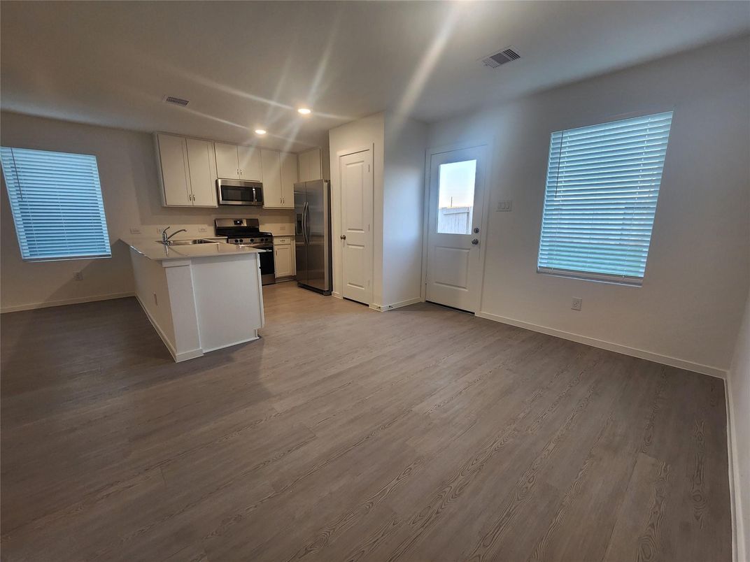 Empty room, Interior, Kitchen, Recessed Lighting, Stainless Steel Appliances, Wood Texture Flooring